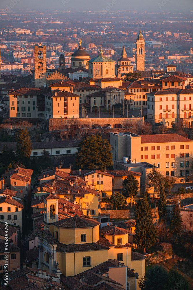 The city of Bergamo, its historic center and the hills, with the lights of the sunset, at the end of a winter day - February 2022.