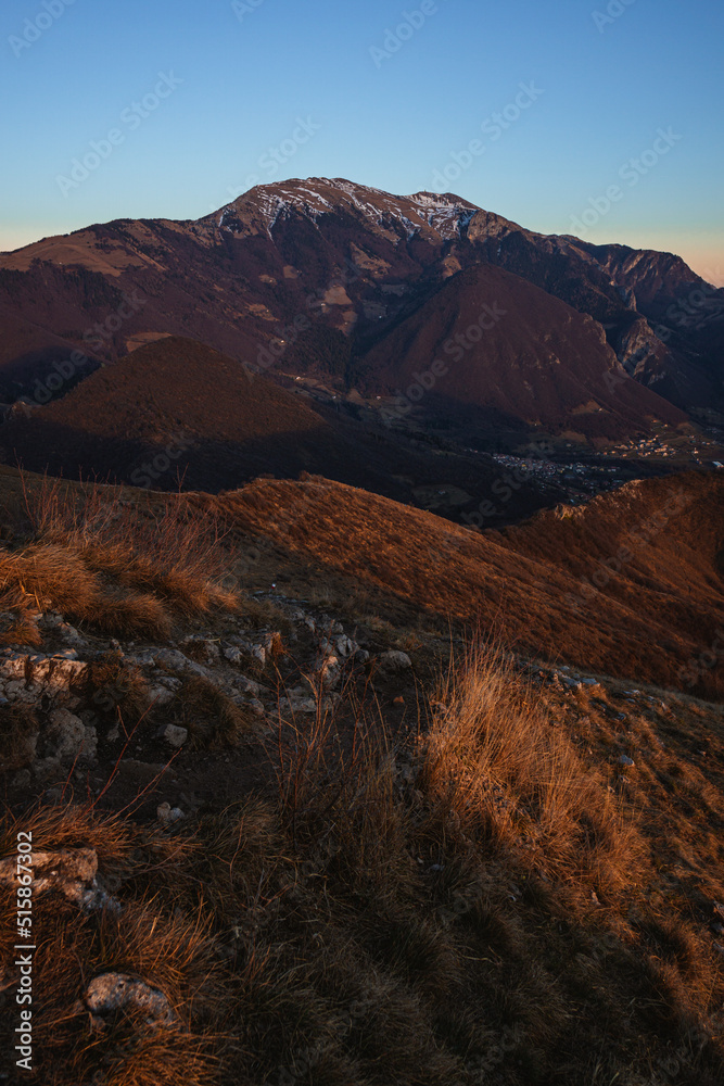 The mountains between val camonica and val seriana, near lake iseo, during the golden hour of a winter day, near the town of Zone, Italy - February 2022.