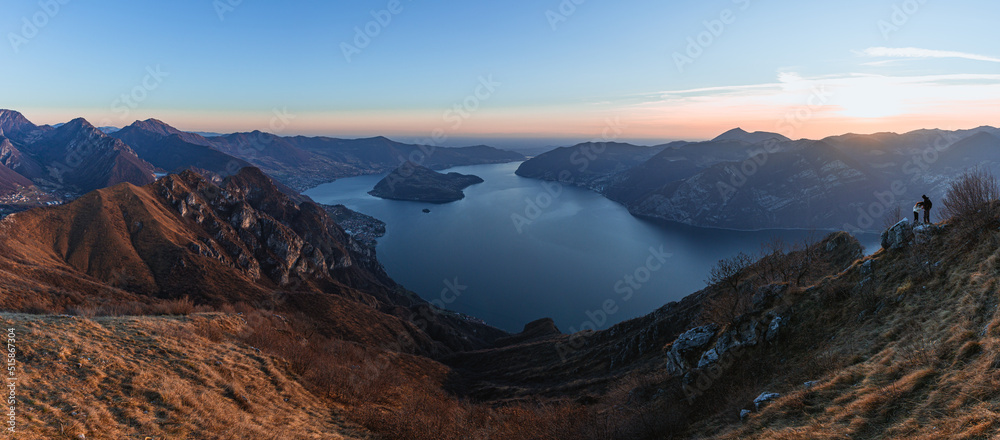 View of Lake Iseo at sunset, with the alps framing it, near the town of Zone, Italy - February 2022.