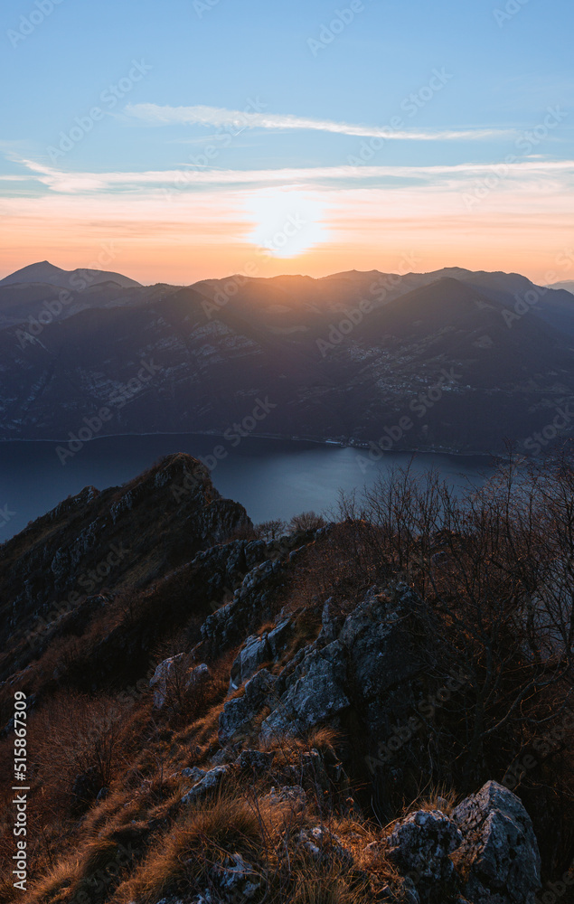 View of Lake Iseo at sunset, with the alps framing it, near the town of Zone, Italy - February 2022.