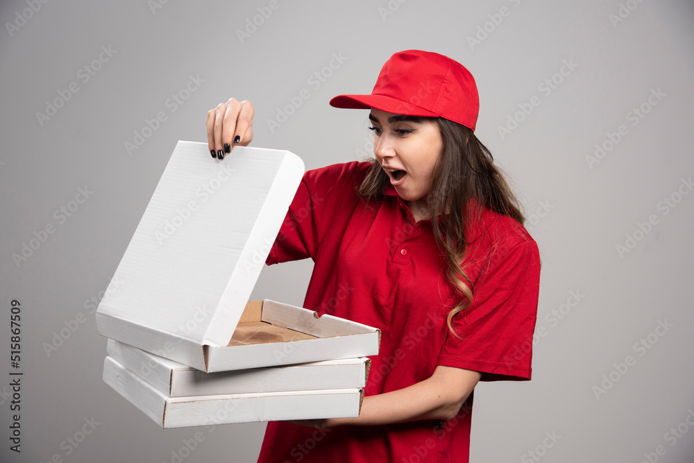 Female courier looking at empty pizza box Female courier looking at empty pizza box