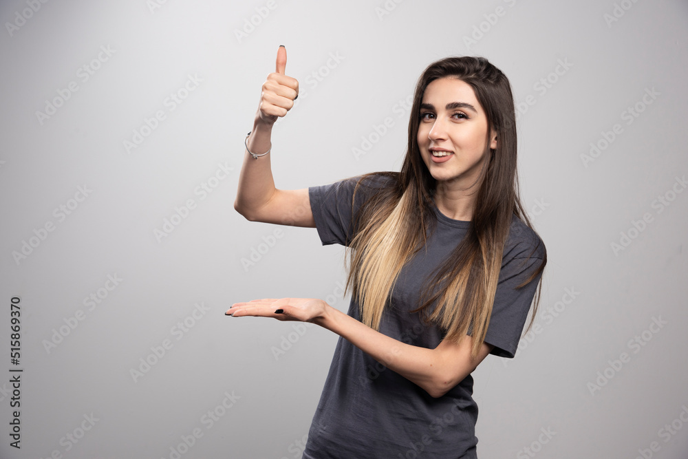 Smiling woman showing her hand and posing Smiling woman showing her hand and posing