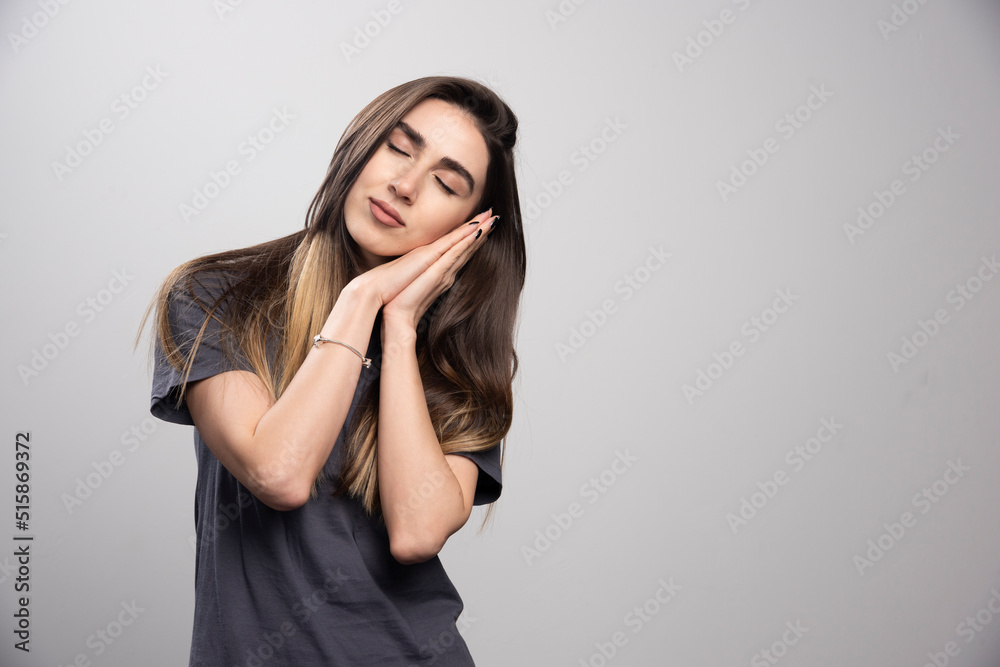 Portrait of a young woman peacefully sleeping shot on a gray background Portrait of a young woman peacefully sleeping shot on a gray background