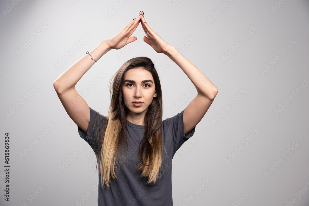 Young woman standing and posing over a gray background Young woman standing and posing over a gray background