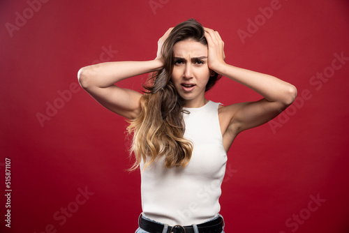 Young pretty brunette woman model posing on a red background