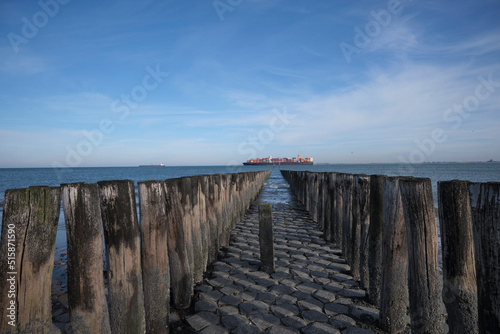 Pier with wooden posts at the North Sea coast in the province of Zeeland, The Netherlands