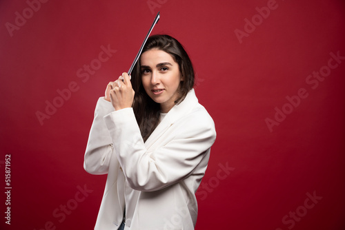 Business woman holding a notebook on a red background