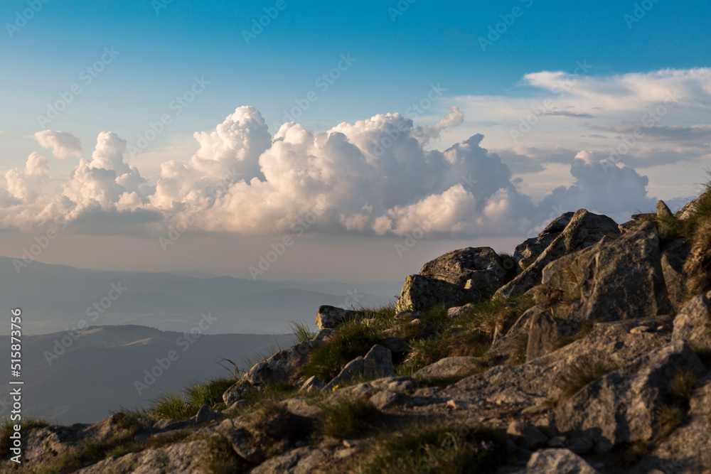 Hiking in the stoned mountains hills during sunset with blue sky and clouds