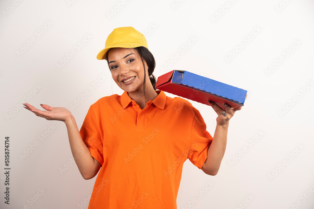 Woman courier in orange uniform and yellow hat with box of pizza Woman courier in orange uniform and yellow hat with box of pizza
