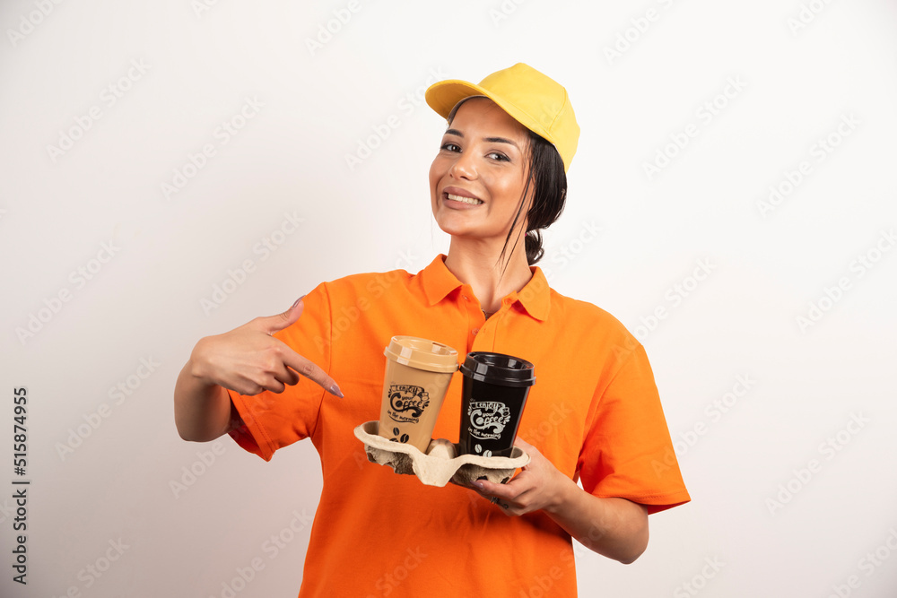 Smiling woman courier holding two cups of coffee Smiling woman courier holding two cups of coffee