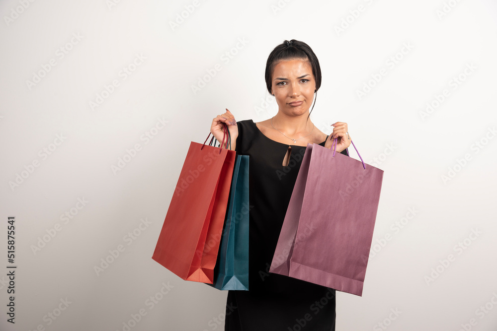 Young woman with shopping bags posing on white background Young woman with shopping bags posing on white background