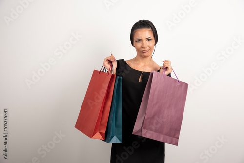 Young woman with shopping bags posing on white background