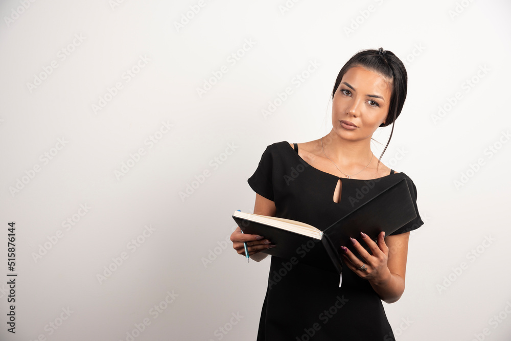 Serious employee posing with open notebook Serious employee posing with open notebook