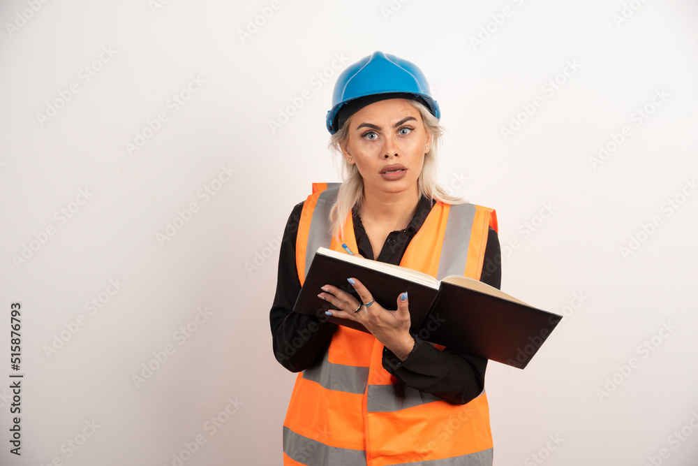 Displeased worker with notebook standing on white background Displeased worker with notebook standing on white background