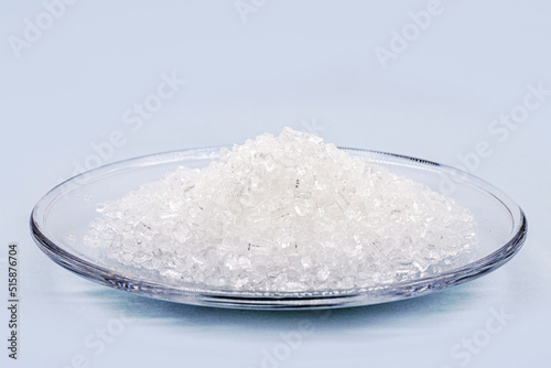 sodium chloride, known as salt or table salt, important food preservative and popular seasoning, isolated on blue background