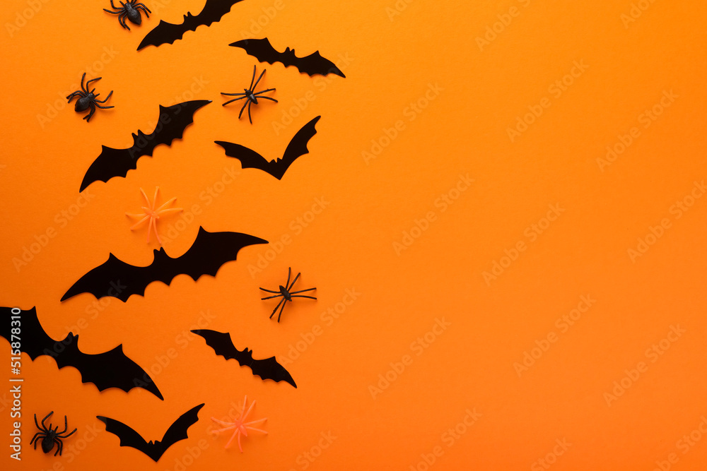 Orange Halloween background. Flock of black bats for Halloween. Black paper bat silhouettes on orange background. Halloween concept, Copy space, top view, overhead.