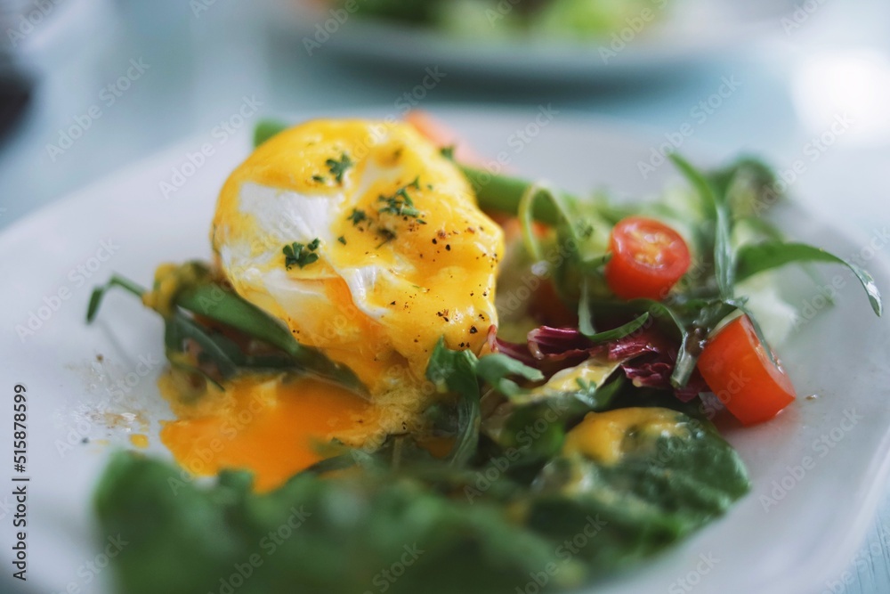 Eggs Benedict on english muffin with smoked salmon and fresh salad on table in restaurant. Eggs Benedict on english muffin with smoked salmon and fresh salad on table in restaurant.