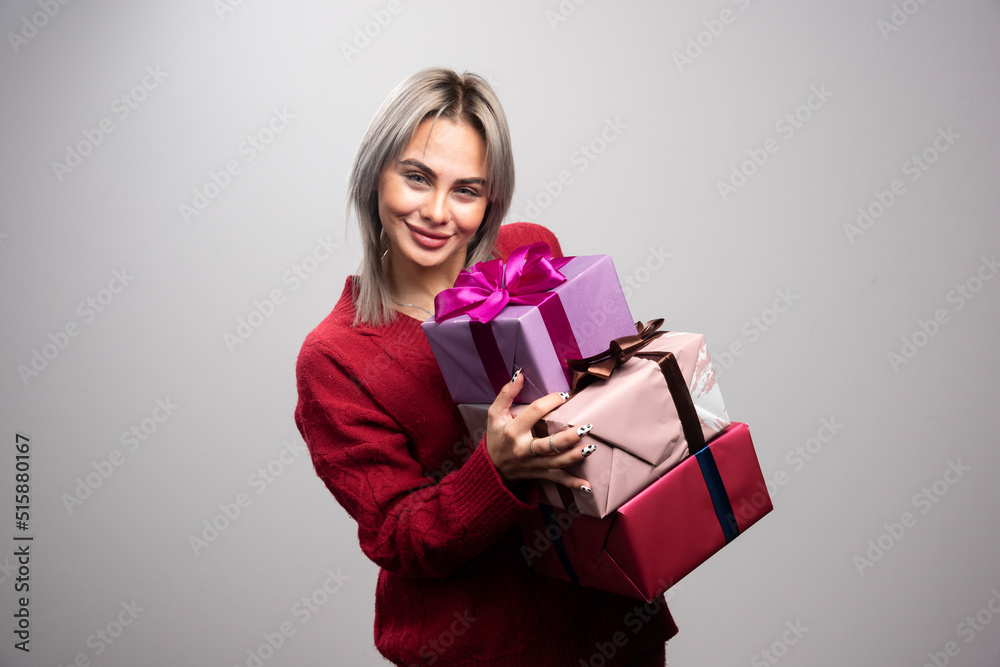 Portrait of happy woman holding her gifts tightly Portrait of happy woman holding her gifts tightly