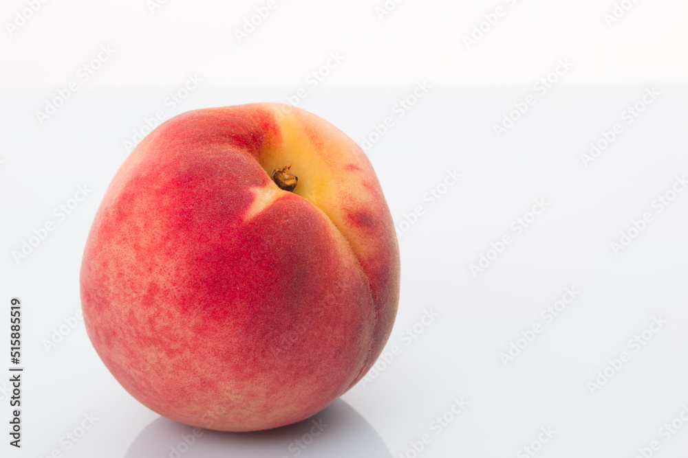A bright red peach on a white background A bright red peach on a white background