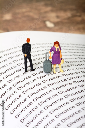 Conceptual image of miniature figure people stood on a book with the words Divorce photo