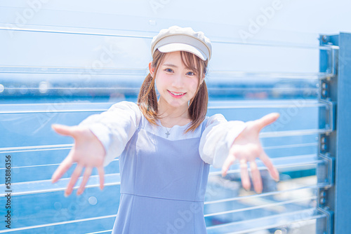 こちらを見つめながら両手を差し出すアジアの若い女性