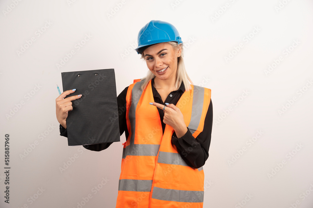 Woman industrial worker pointing at clipboard on white background Woman industrial worker pointing at clipboard on white background