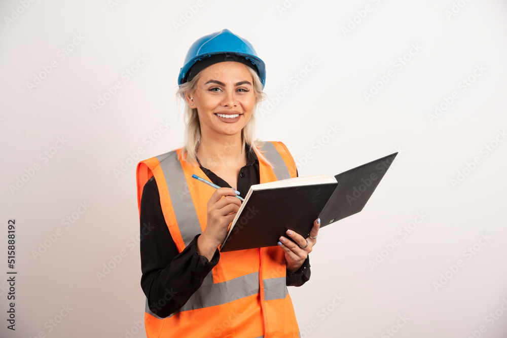 Positive construction worker writing in notebook Positive construction worker writing in notebook