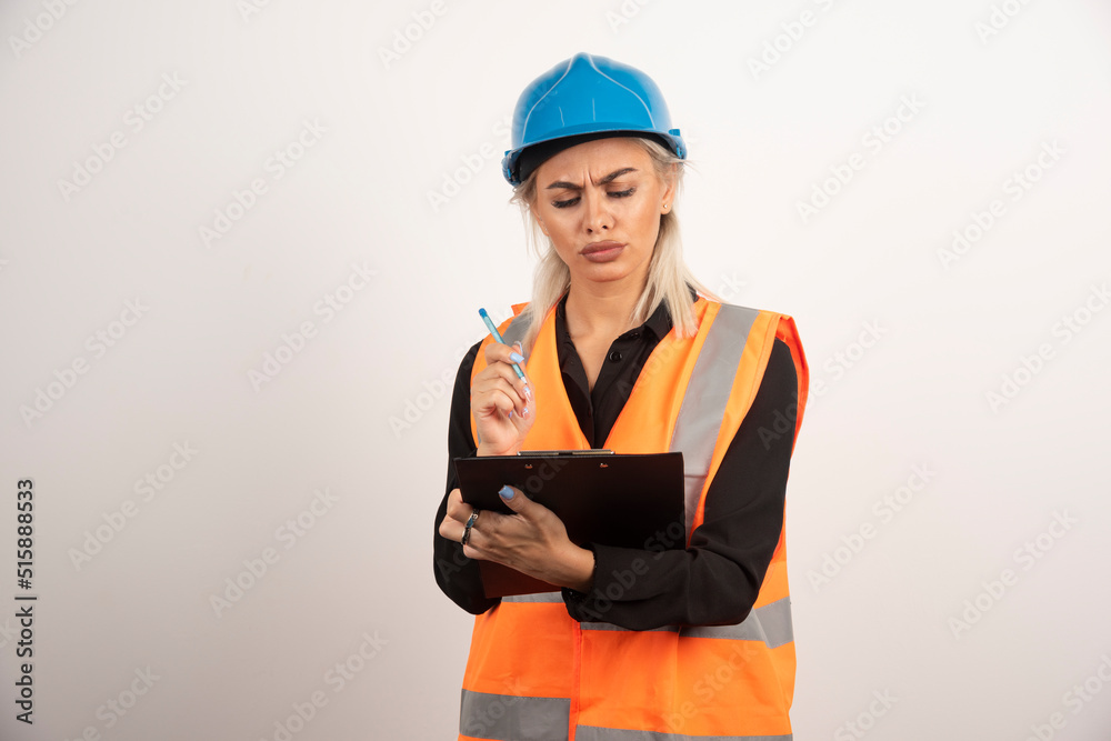 Female engineer checking notes on white background Female engineer checking notes on white background