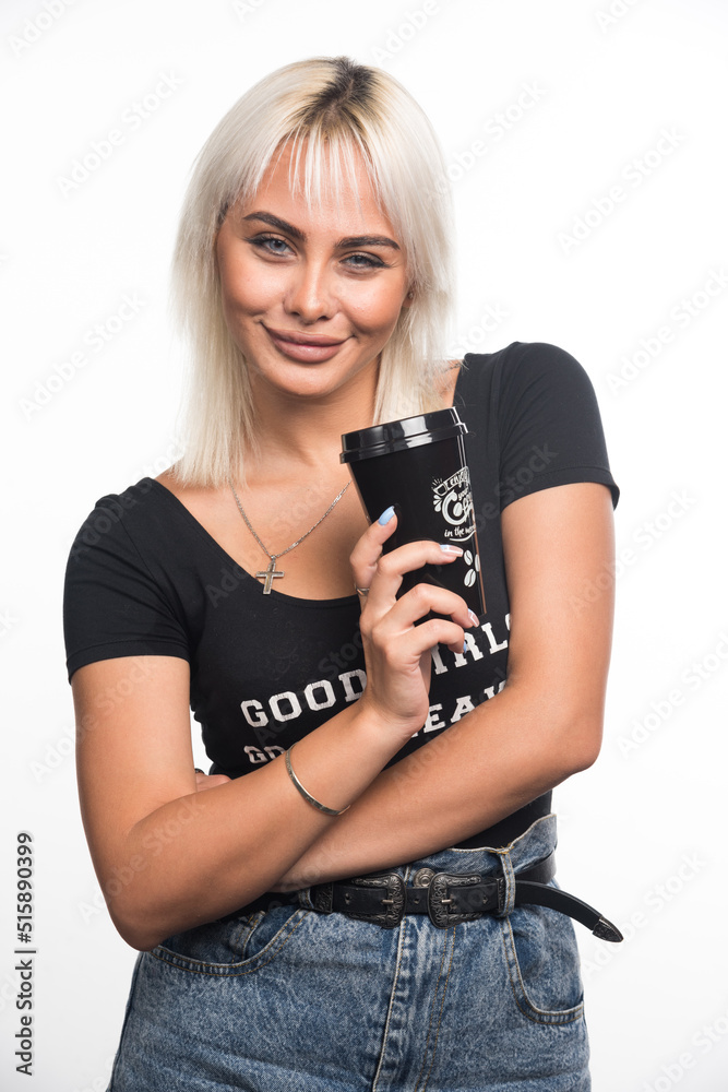 Young woman holding cup of coffee on white background with arms crossed Young woman holding cup of coffee on white background with arms crossed