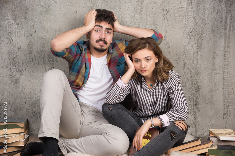 Photo of young couple sitting on the floor with books Photo of young couple sitting on the floor with books