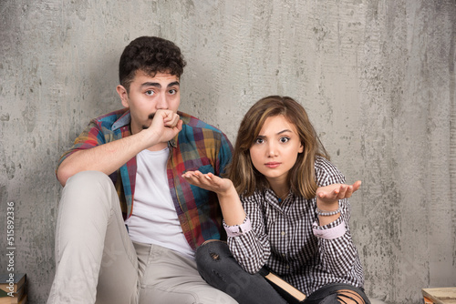 Photo of young couple sitting on the floor