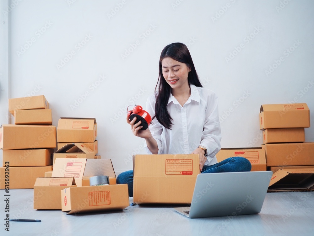 Cheerful Asian people checking order online on laptop,Asian woman packing parcel at home. Cheerful Asian people checking order online on laptop,Asian woman packing parcel at home.