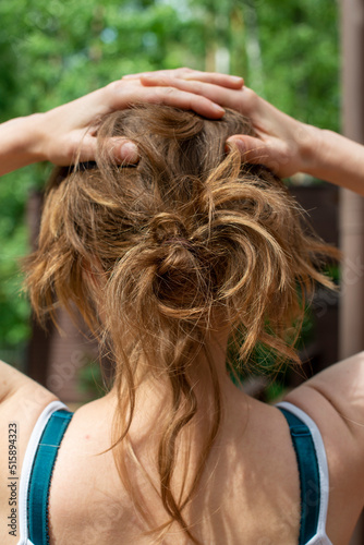 Natural unbrushed hair of a young woman in a messy up do hairstyle. photo