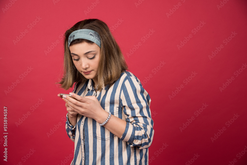 Naklejka premium Adorable girl checking messages on telephone