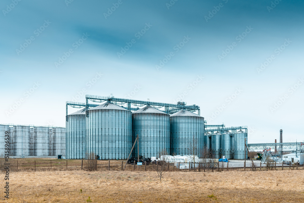 Modern complex for drying,cleaning and storage a grain.Overcast blue cloudy sky spring,autumn background.