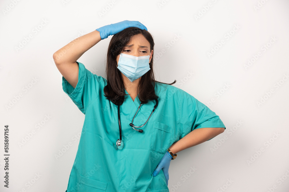 Perplexed doctor in medical mask and gloves on white background Perplexed doctor in medical mask and gloves on white background