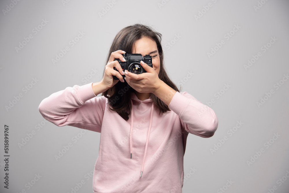Young woman in sweatshirt taking photos