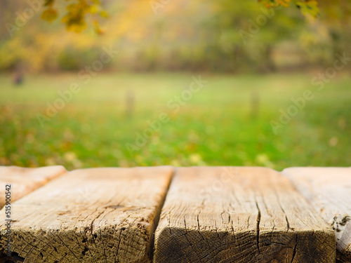 Empty wooden table on the background of picturesque autumn nature. Close-up. There is no one in the photo. Camping, fresh air, family vacation, vacation with friends, picnic.