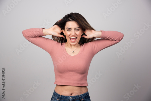 Beautiful young girl posing and covering her ears with her hands