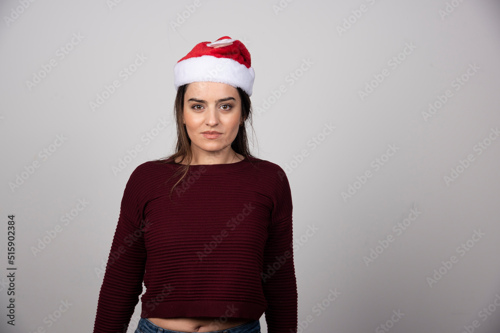 Photo of young woman in Christmas hat looking at the camera