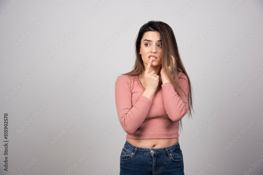 A pensive woman in pink t-shirt standing and posing A pensive woman in pink t-shirt standing and posing