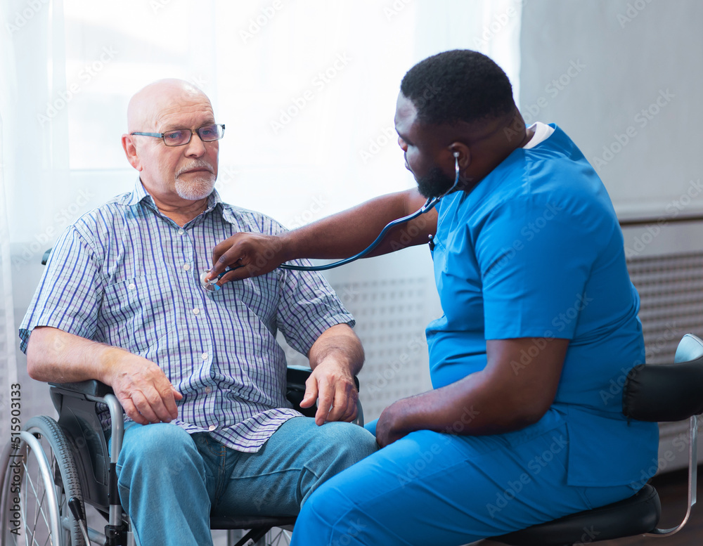 Obraz premium Professional doctor helps an elderly man with chronic diseases. Therapist and patient in home interior. Health care and medicine concept.