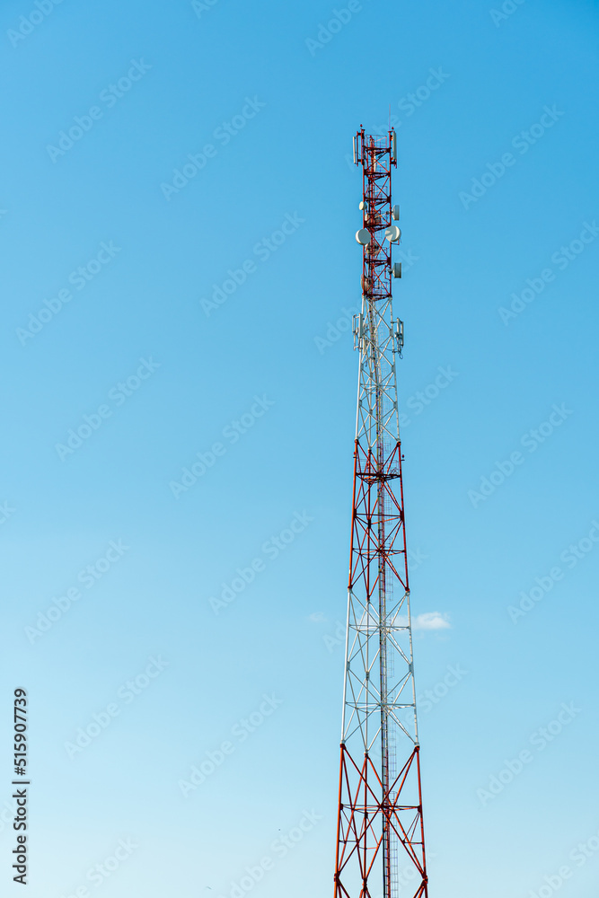 New GSM antennas on a high tower against a blue sky for transmitting a 5g signal are dangerous to health. Radiation pollution of the environment through cell towers. The threat of extinction