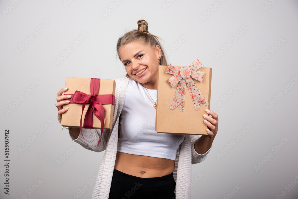 Smiling woman showing holiday gifts with happy expression Smiling woman showing holiday gifts with happy expression