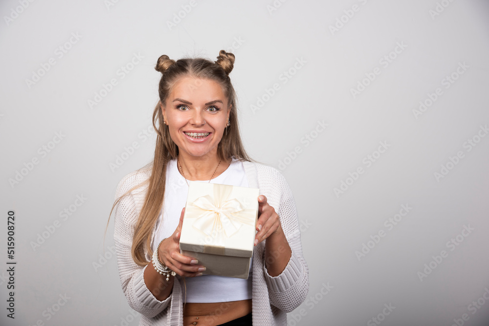 Photo of smiling woman holding a gift box Photo of smiling woman holding a gift box
