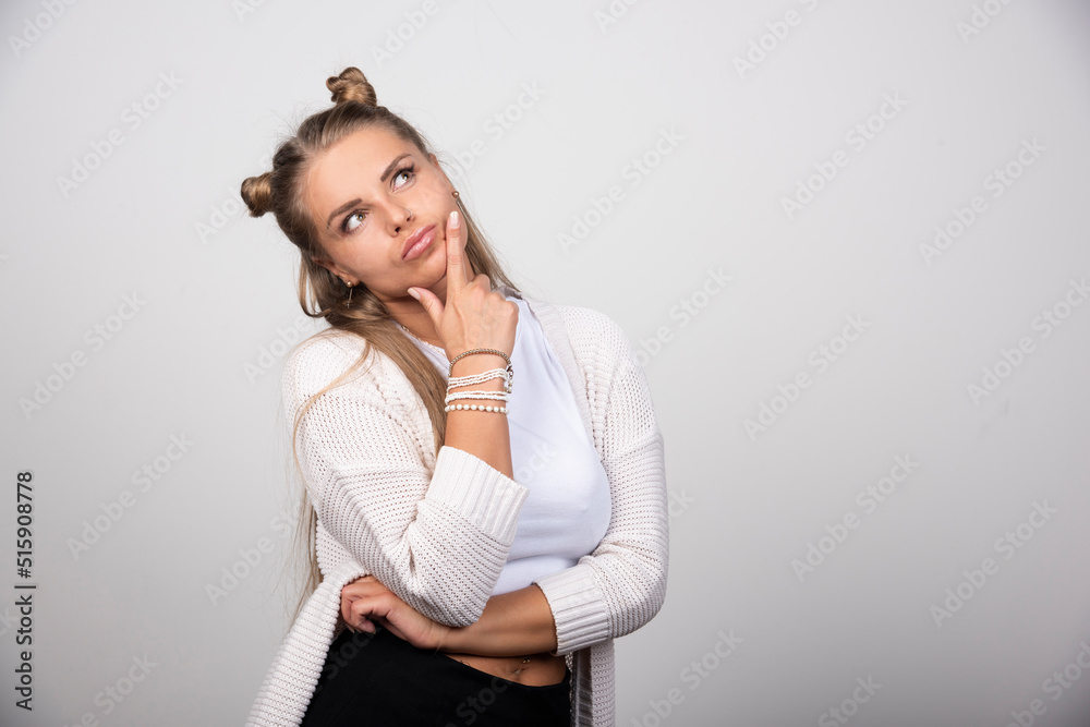 Portrait of thoughtful girl looking up and holding hand on chin Portrait of thoughtful girl looking up and holding hand on chin