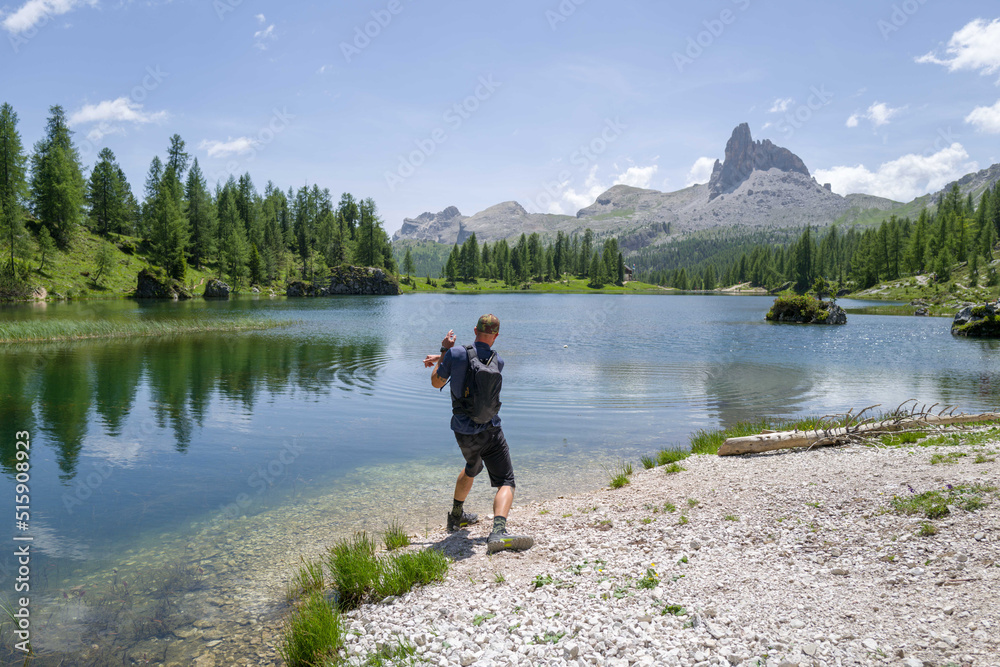 Man throwing stone in the water in the lake Man throwing stone in the water in the lake