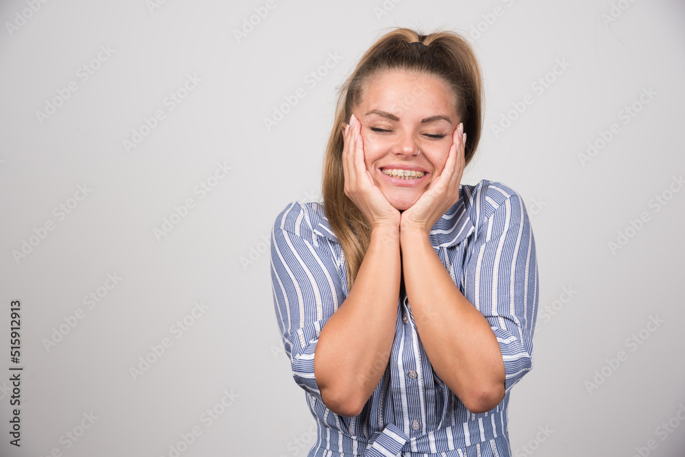 Woman in blue sweater holding her face Woman in blue sweater holding her face
