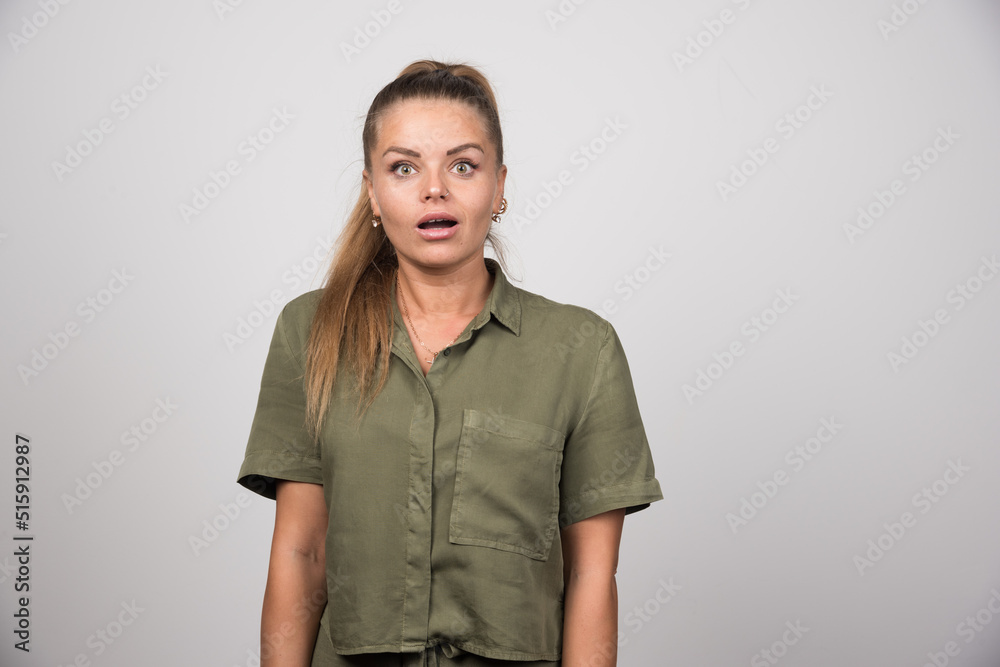 Young woman in green sweater standing on gray background Young woman in green sweater standing on gray background