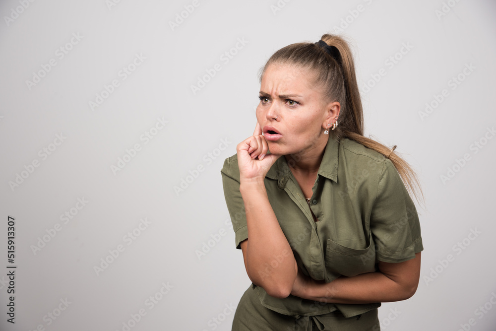 Young woman looking at something on gray background Young woman looking at something on gray background